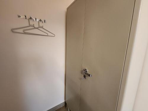 a bathroom door with four hangers on the wall at Sai Sharad Guest House in Naozor