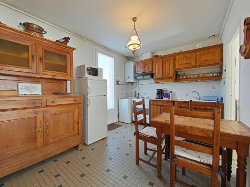 une cuisine avec une table et un réfrigérateur blanc dans l'établissement Maison 3 pièces près plage avec jardin - FR-1-224-106, à Saint-Gilles-Croix-de-Vie