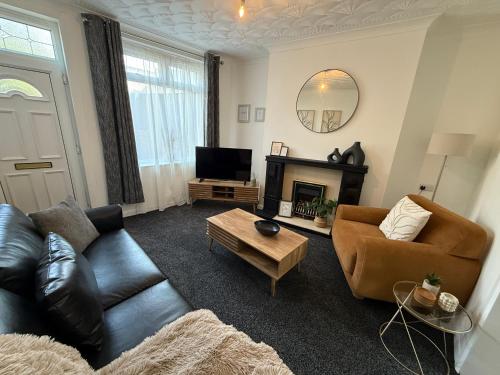 a living room with a couch and a tv at 3 bed Jct 37 M1 luxury stay! in Barnsley