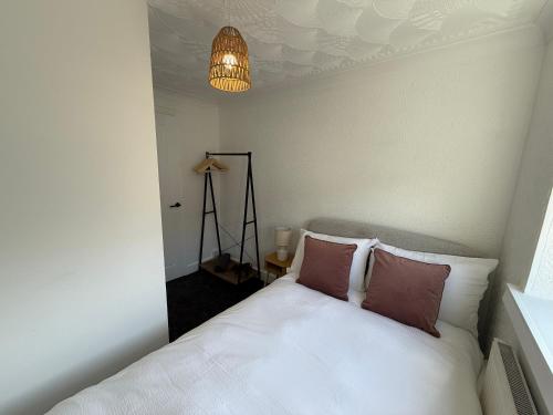 a bedroom with a white bed and a chandelier at 3 bed Jct 37 M1 luxury stay! in Barnsley