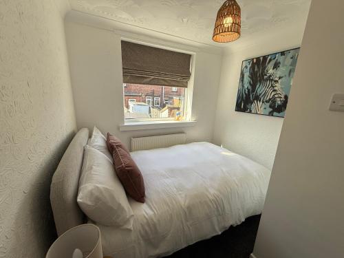 a bedroom with a white bed and a window at 3 bed Jct 37 M1 luxury stay! in Barnsley