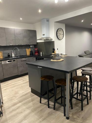 une cuisine avec un grand îlot et des tabourets de bar dans l'établissement Agréable maison de ville, à Saint-Péray