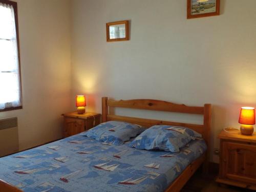 - une chambre avec un lit avec une couette bleue et 2 lampes dans l'établissement Maison 3 pièces avec jardin, proche plage à Noirmoutier - FR-1-224B-681, à Noirmoutier-en-l'lle
