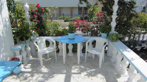 a table and chairs on a patio with flowers at Sandalis Hotel in Pythagoreio