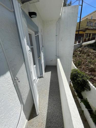 a hallway of a white building with an open door at Spanos Studios - Panteli in Panteli
