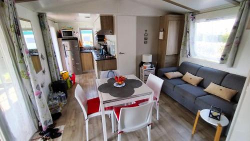 un salon avec un canapé, une table et des chaises dans l'établissement Mobilhome, à Saint-Arnoult