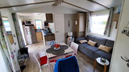un salon avec un canapé bleu et une table dans l'établissement Mobilhome, à Saint-Arnoult