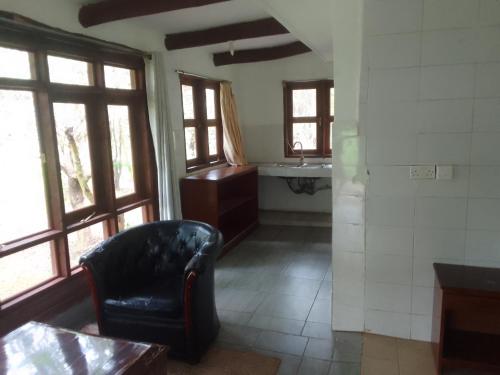 a living room with a chair and a sink at Suswa Ranch Resort in Gicheru