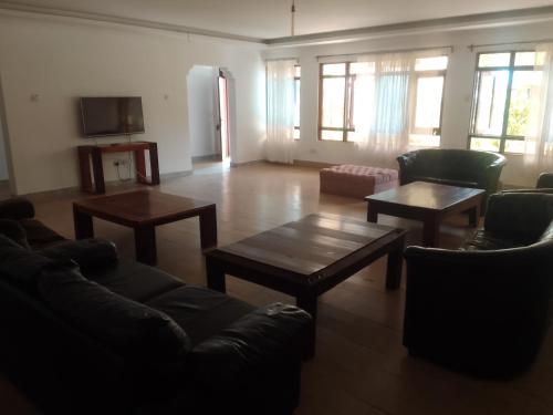a living room with couches and tables and windows at Suswa Ranch Resort in Gicheru
