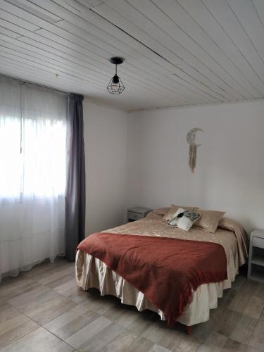 una camera da letto con un letto con una coperta rossa di La Guarida a Pergamino