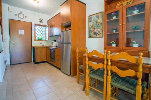 a kitchen with wooden cabinets and a table and chairs at Casa Costa near the beach in Kassandria