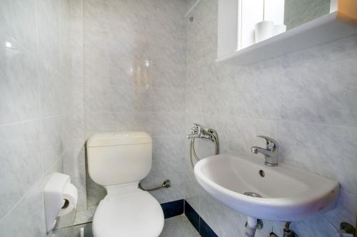a bathroom with a white toilet and a sink at Casa Costa near the beach in Kassandria