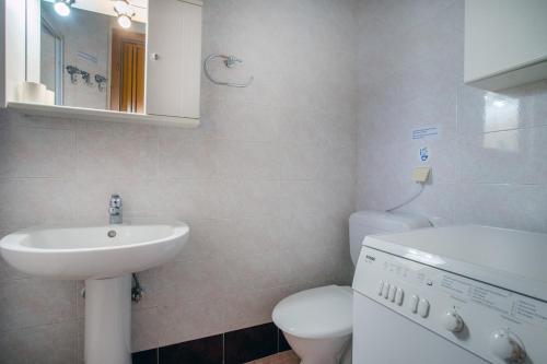 a white bathroom with a sink and a toilet at Casa Costa near the beach in Kassandria
