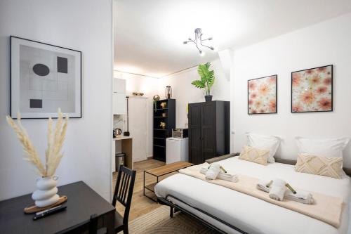 une chambre avec un lit et une table dans une pièce dans l'établissement Studio à 2 min métro 13 - accès Paris Champs-Élysées, à Asnières-sur-Seine