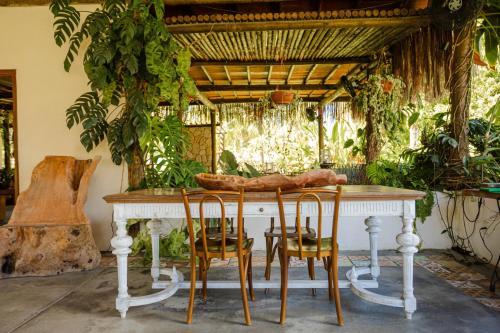 a table and chairs in a room with plants at Ocacocar - Milagres in São Miguel dos Milagres