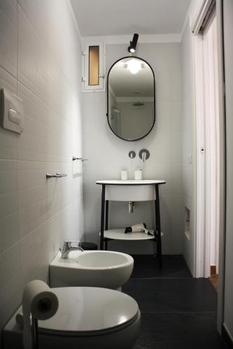 a bathroom with a sink and a toilet and a mirror at Caracciolo Lounge in Cefalù