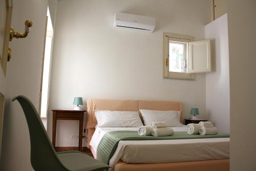 a bedroom with a bed with two towels on it at Caracciolo Lounge in Cefalù