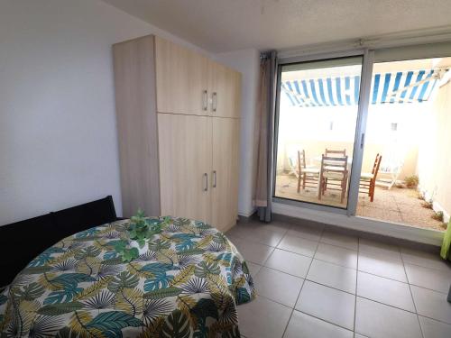 une chambre avec un lit et une vue sur la plage dans l'établissement Studio cabine refait à neuf avec terrasse, piscine, parking et lave-linge - Le Grau-du-Roi - FR-1-307-249, au Grau-du-Roi