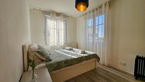 une chambre avec un lit et une grande fenêtre dans l'établissement Appartement T3 à 5 min de Disney et 25min de Paris, à Bussy-Saint-Georges