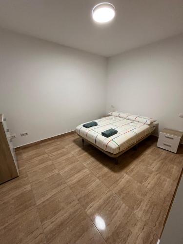 1 dormitorio con 1 cama en una habitación con suelo de madera en APARTAMENTOSOLyMAR, en Oropesa del Mar