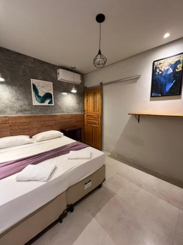 a bedroom with a bed and a wall at Pousada Nativos Lençois in Lençóis