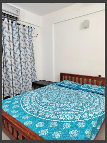 Un dormitorio con una cama con una manta azul encima. en Flat in Kochi 403, en Ernakulam