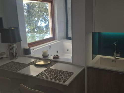 a bathroom counter with a sink and a window at Penthouse Ipsos Marina in Ipsos