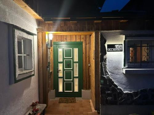 a green door on a house with a window at VillaVoigt, een Gezellig Familiehuis in Äussere Kainisch