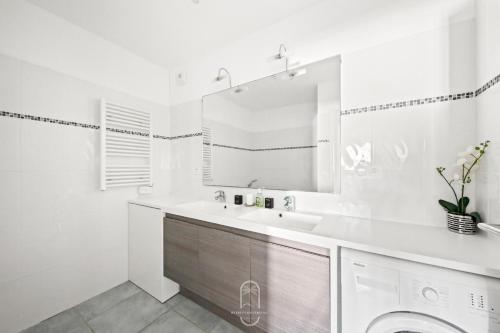a white bathroom with a sink and a washing machine at Au bout de la rue la Mer- T3 Jardin Piscine PARKING WIFI BY HC in Carqueiranne