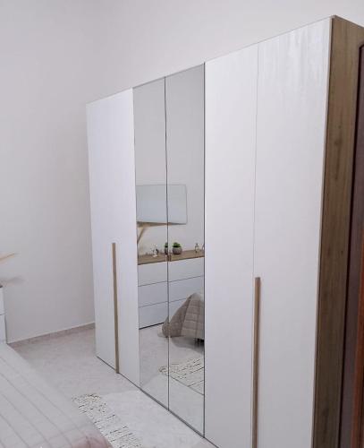 un armario blanco con puertas de cristal en una habitación en Appartamento Matteo, en Trappeto