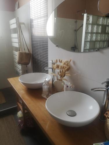 La salle de bains est pourvue de 2 lavabos blancs sur un comptoir en bois. dans l'établissement Appartement bourgeois 2 chambres 4 pers Perpignan Centre, à Perpignan