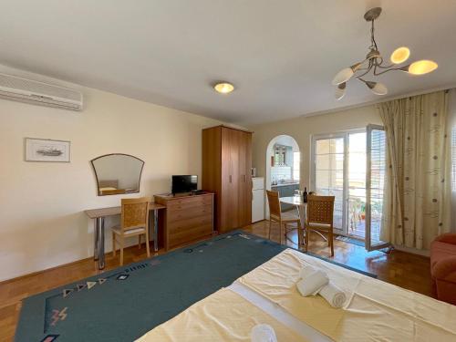 Un dormitorio con una cama, un escritorio y una mesa. en Stella Maris, en Kukljica