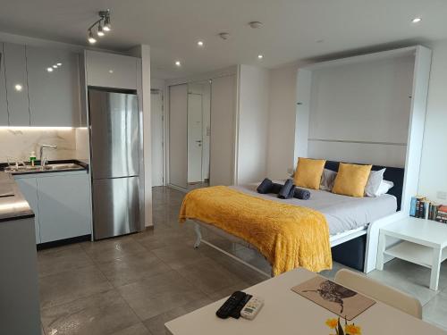 a bedroom with a bed and a kitchen at E1 Studios, Sea & Beach Views, High Floor in Gibraltar