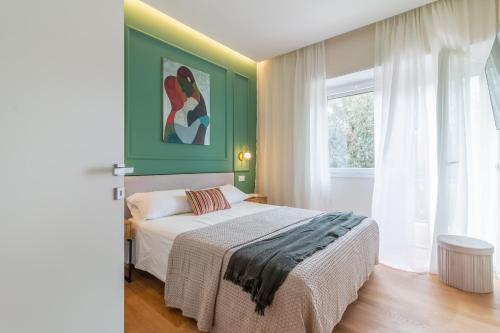 a bedroom with a bed with a green wall at Sweet Home 23 in Campagnano di Roma