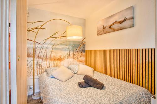 ein Schlafzimmer mit einem Bett und einem Kissen darauf in der Unterkunft Les Dunes - Jardin Privatif - Plage à 500 Mètres in Merville-Franceville-Plage