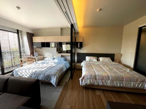 a bedroom with two beds and a living room at 4Pax MRT BTS Asoke, Terminal21 in Bangkok