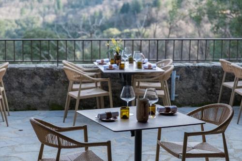 two tables and chairs on a patio with a view at Les Terrasses de la Borie in Mandagout