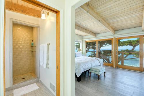 een slaapkamer met een bed en een inloopdouche bij Luxury Ocean Front Cambria Beach House in Cambria