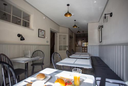 ein Esszimmer mit Tischen, Stühlen und einem Laptop in der Unterkunft Poduszka Apartamenty Kamienica in Pasłęk