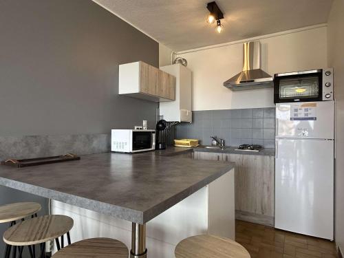 Il comprend une cuisine équipée d'un comptoir et d'un réfrigérateur blanc. dans l'établissement Appartement 4 couchages, terrasse, parking, animaux admis - Banyuls-sur-Mer - FR-1-225C-99, à Banyuls-sur-Mer