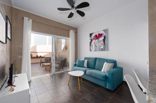 un salon avec un canapé bleu et une table dans l'établissement Apartment Clara Fañabe, à Adeje