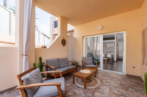 un salon avec des chaises, un canapé et une table dans l'établissement Apartment Clara Fañabe, à Adeje