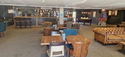 a restaurant with tables and couches and a bar at HolidayLet 24 Bude Newperran Holiday Park in Cubert