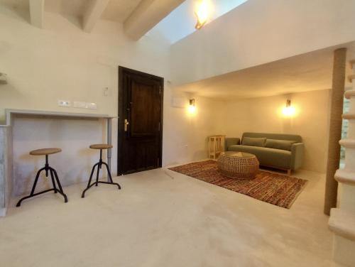 a living room with a couch and two stools at La Casita de La Abubilla in L'Aldea