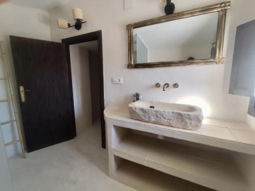 a bathroom with a stone sink and a mirror at La Casita de La Abubilla in L'Aldea