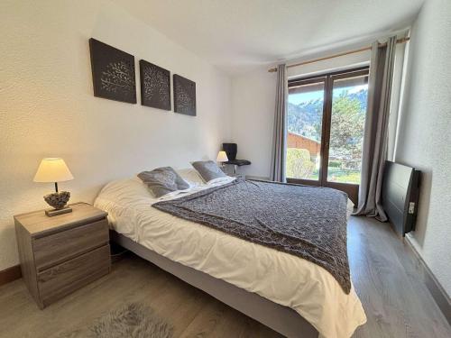 une chambre avec un grand lit et une fenêtre dans l'établissement Appartement cosy 2 chambres à Praz-sur-Arly, proche centre et pistes, parking sécurisé - FR-1-603-72, à Praz-sur-Arly