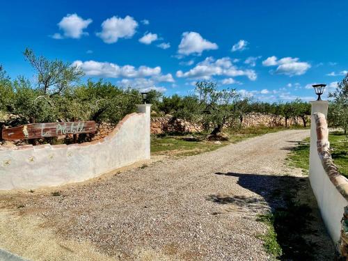 a dirt road with a fence on the side at La Casita de La Abubilla in L'Aldea
