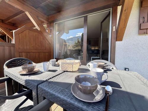 une table avec des assiettes et des tasses en haut dans l'établissement Appartement cosy 2 chambres à Praz-sur-Arly, proche centre et pistes, parking sécurisé - FR-1-603-72, à Praz-sur-Arly