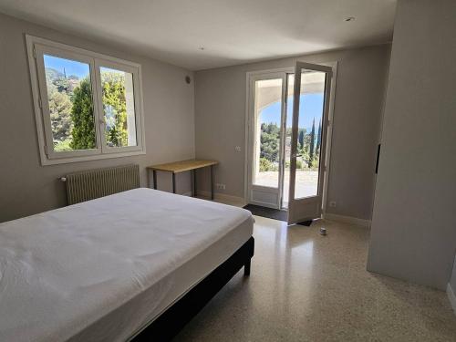 une chambre avec un grand lit et deux fenêtres dans l'établissement Rez de villa avec piscine privée chauffée et jardin, à 1 km de la mer - FR-1-768-79, à Saint-Peïre-sur-Mer