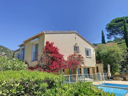 une maison avec un arbre rouge à côté d'une piscine dans l'établissement Villa à Aiguebelle avec piscine privée et climatisation, près de la plage - FR-1-308-190, au Lavandou